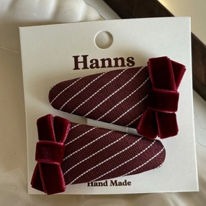 Pair of burgundy checkered fabric hair clips with velvet bows on a display card