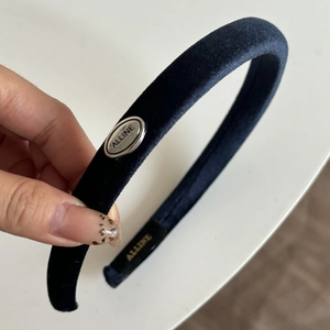 Detail of Prussia blue velvet headband with oval silver metal ALLINE brand plaque