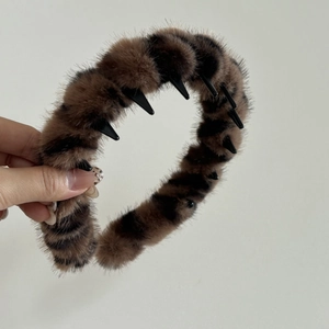 Detail of plush animal print headband with non-slip interior teeth and soft brown fur
