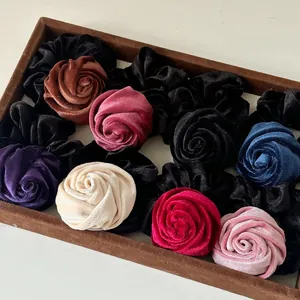 Macro shot of colorful velvet rose hair ties showing premium texture and floral details