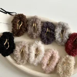 Détail de pinces à cheveux ovales en peluche de couleurs variées sur un plateau