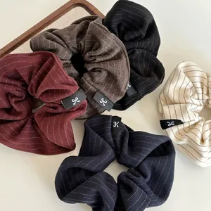 Five-pack set of large pinstripe fabric scrunchies in assorted colors with logo labels