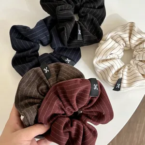 Detail of five-color striped scrunchie set with woven texture and bow labels