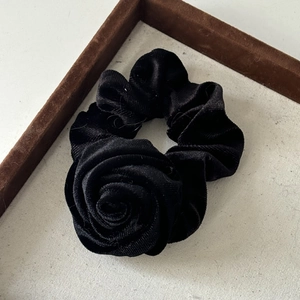 Detail of a vintage black velvet rose scrunchie with layered fabric texture and high elasticity
