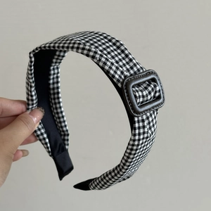 Detail of vintage black and white gingham headband with a brown resin buckle accent