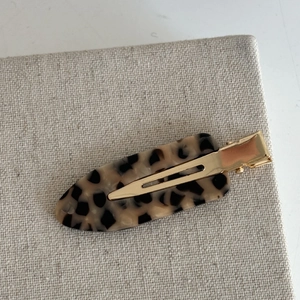 French leopard print hair clip with tortoiseshell pattern and golden metal base