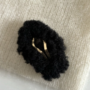 Vue macro de la pince à cheveux nuage en peluche noire avec base en métal doré