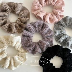 Flache Darstellung handgefertigter Strick-Haargummis mit weicher Mohair-Textur