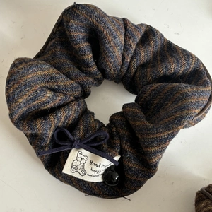 Detail of tweed scrunchie with herringbone weave pattern and cute bear handmade label