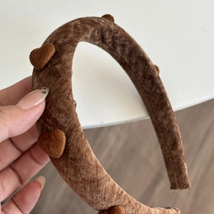 Nahaufnahme brauner Samt-Haarreif mit weicher Wattierung und 3D-Herz-Details