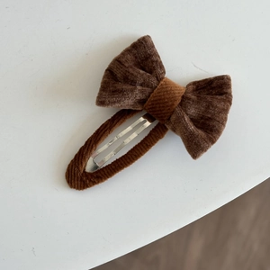 Detail einer braunen Cord-Schleifen-Haarspange mit stoffumhüllter BB-Druckknopfbasis