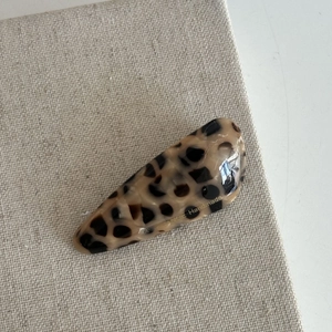 Detail of leopard print hair clip showing handmade texture and glossy acetate finish