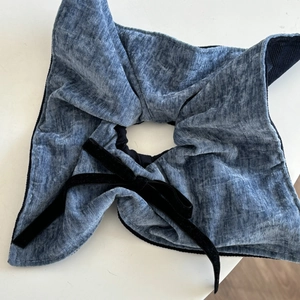 Nahaufnahme von blauem Samt-Haargummi mit schwarzem Schleifendetail
