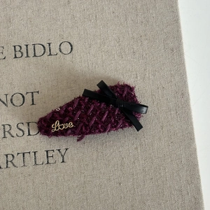 Close-up of vintage purple tweed hair clip with black leather bow and gold Love metal detail