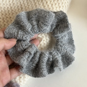 Nahaufnahme des grauen Strick-Scrunchies aus Mohair mit weicher, flauschiger Textur