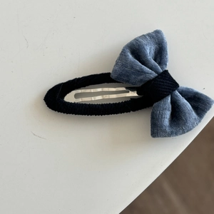Detailansicht der blauen Samt-Bogenspange mit schwarz umwickeltem Metall-BB-Clip-Gewebe