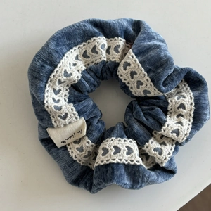 Detailansicht eines blauen Samt-Haargummis mit Herzspitze und kleinem Stoffetikett