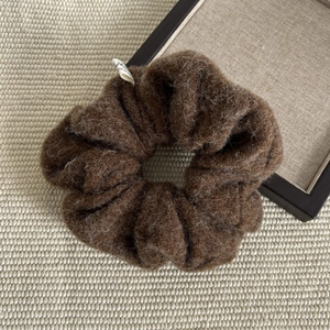 Detailed close-up of a brown oversized plush scrunchie with soft faux mohair texture