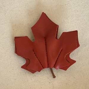 Retro maple leaf leather hair clip in reddish brown with detailed vein stitching