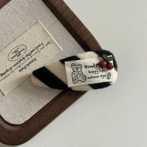 Knitted bear hair clip with black and white stripes and red cherry accents for women
