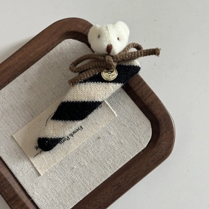 Detail of bear striped scrunchie with Believe In metal tag and brown bow accessory