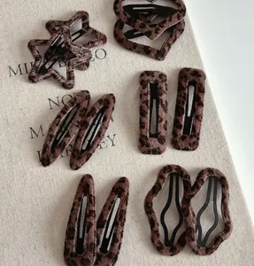 Dettaglio di fermagli per capelli maculati a forma di stella, cuore e geometrici