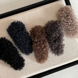 Detailed view of plush teddy fur snap hair clips in five assorted winter colors