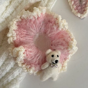 Gros plan sur chouchou au crochet avec ours en feutre blanc et détail nœud
