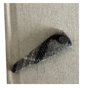 Vintage grey plaid fabric hair clip with a round silver metallic brand tag detail