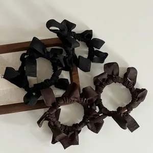 Elegant bow hair tie set in black and dark coffee colors with vintage pleated fabric texture