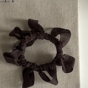 Macro detail of coffee brown pleated chiffon hair scrunchie with layered wave texture