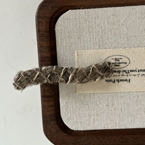Detailed macro view of French wool-wrapped hair clip with vintage knitting texture