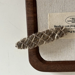 Close-up of vintage mixed-weave wool hair clip with brown and cream braided texture
