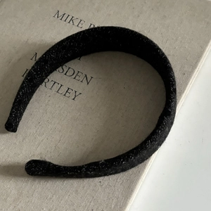 Close-up of black velvet padded headband featuring soft texture and classic U-shape