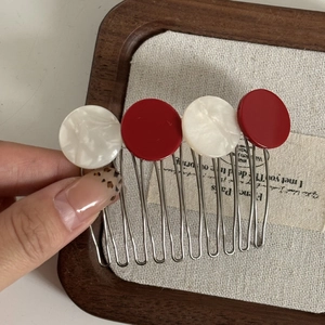Détail du peigne à cheveux rouge et blanc avec base en métal argenté à 10 dents
