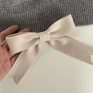Minimalist cream knit bow hair clip with ribbed texture for elegant feminine hairstyling