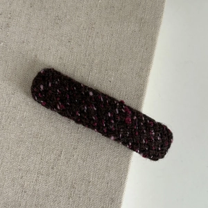 Close-up detail of plum purple tweed knit texture on a long winter hairpin clip