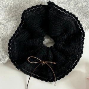Chouchou élégant en maille noire pour femme avec bords ondulés et détail de nœud brun
