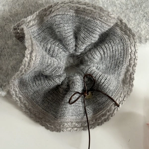 Chouchou en maille pelucheuse grise avec nœud marron et détails métalliques élégants