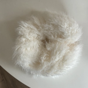 Detail of soft white oversized plush scrunchie with fluffy faux fur texture for hair