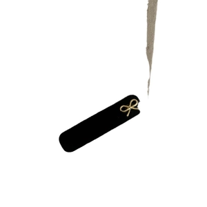Barrette élégante en velours noir ornée d'un nœud doré raffiné sur fond blanc épuré