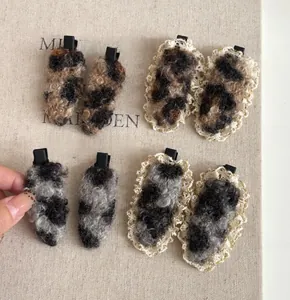 Dettaglio di fermagli per capelli in peluche leopardato marrone con pizzo e clip a coccodrillo