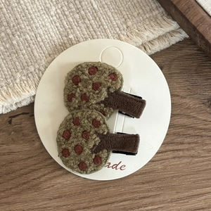 Detailed close-up of forest-style handmade rabbit tree hair clips with green embroidery