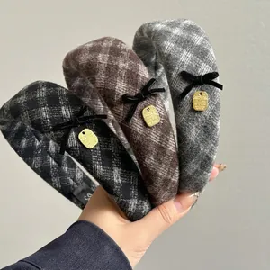 Three elegant plaid velvet headbands with black bows and golden metal tags for women