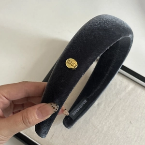 Detail of grey velvet padded headband with gold Believe metal charm and handmade label