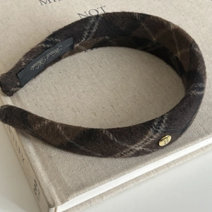 Detail shot of plaid wool headband with gold button accent and handmade inner label
