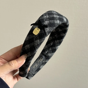 Close-up of handmade plaid headband with velvet bow and gold coin charm detail
