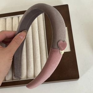 Serre-tête en velours rose et gris avec cœur et breloque dorée, vue tenue en main