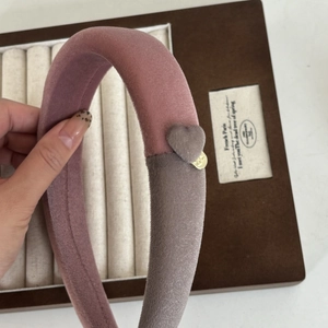 Détail du serre-tête en velours bicolore rose et gris avec décoration cœur et breloque