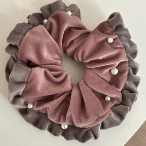 Chouchou en velours rose et gris avec perles blanches et bords volantés sur fond blanc